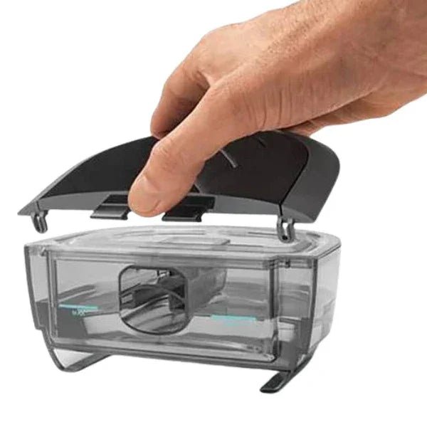 Hand opening transparent CPAP humidifier water chamber on white background