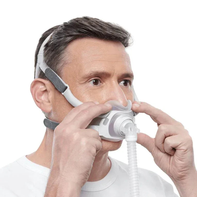 Man wearing and adjusting nasal CPAP mask for sleep apnea therapy