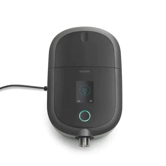 Top view of black CPAP machine with digital display and power cord on white background