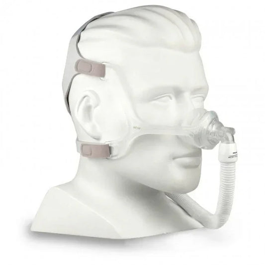 Nasal CPAP mask with headgear and hose on mannequin for sleep apnea therapy