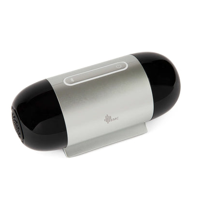 A portable Travel Auto CPAP Machine with a glossy black and silver metallic body, resting on a small white stand against a white background.
