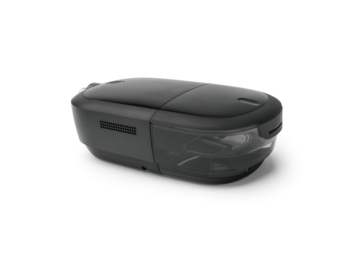 A sleek, dark gray CPAP device with a glossy top lid and a semi-transparent front window, shown from a three-quarters perspective on a clean white background.
