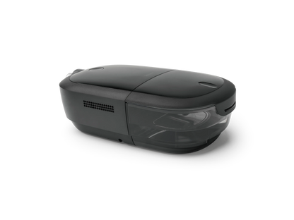 A sleek, dark gray CPAP device with a glossy top lid and a semi-transparent front window, shown from a three-quarters perspective on a clean white background.
