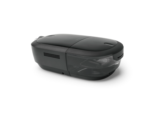 A sleek, dark gray CPAP device with a glossy top lid and a semi-transparent front window, shown from a three-quarters perspective on a clean white background.
