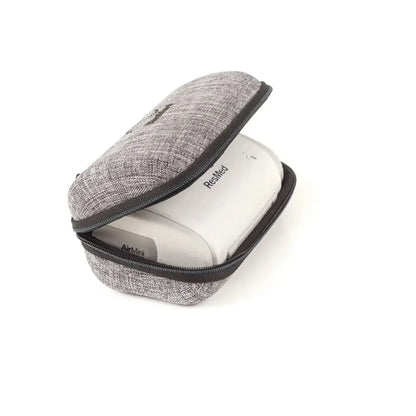 A gray textured zippered carrying case with black trim, shown open with a white ResMed AirMini device inside, on a plain white background.